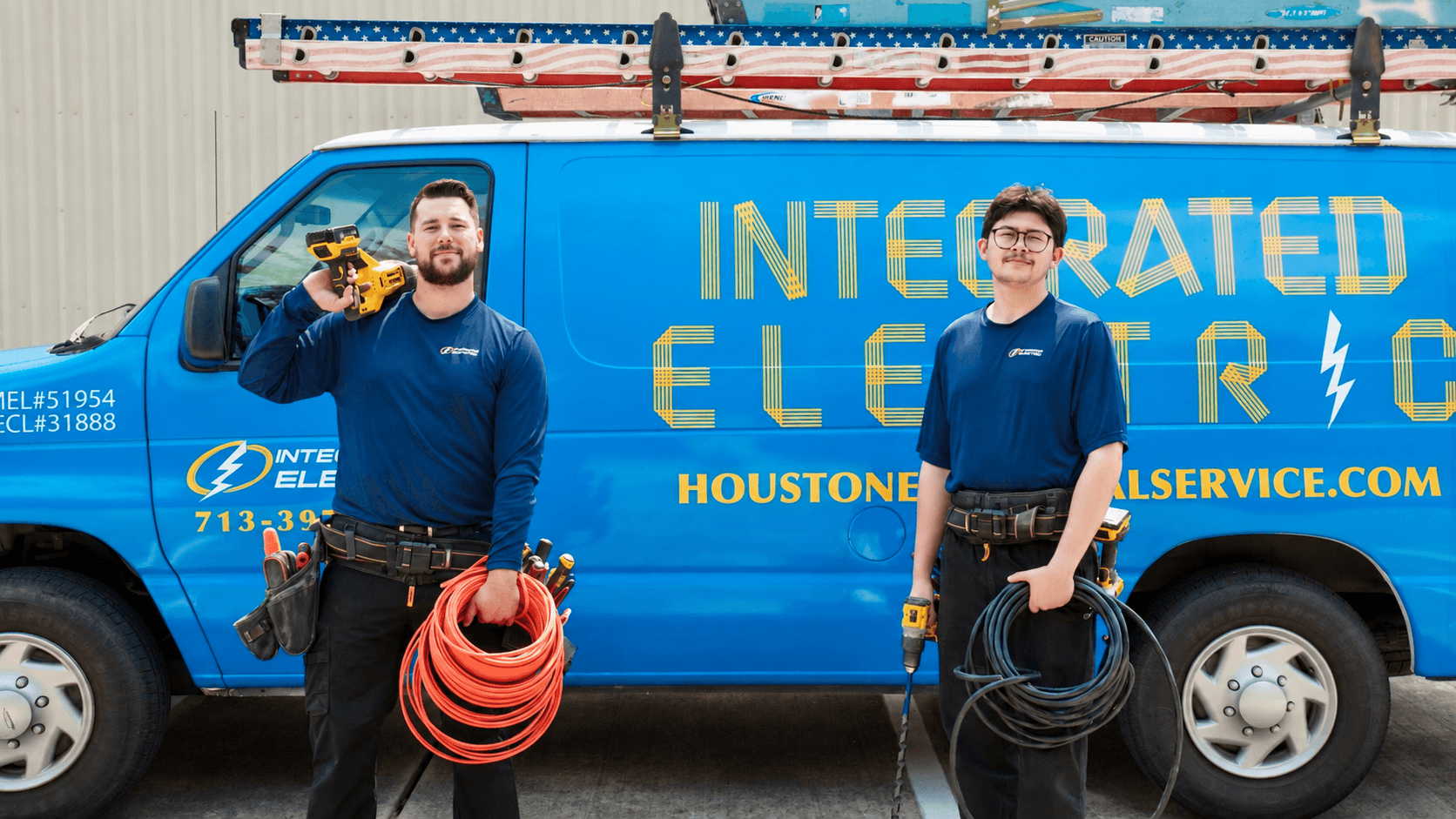 Integrated Electric electricians standing in front of a branded service van
