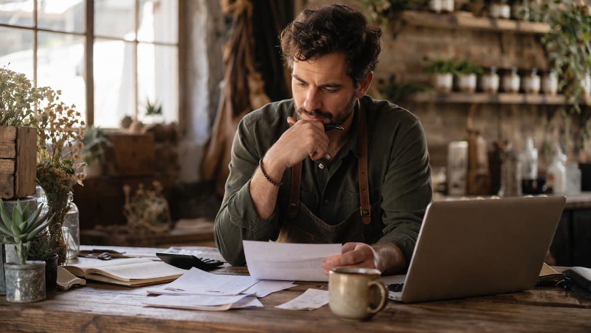 Warm editorial image of a local business owner reviewing notes at a counter, representing diagnosis before tactics.